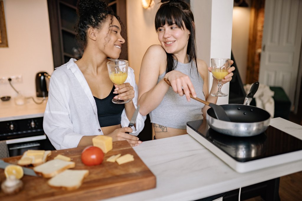 Um casal de mulheres cozinha juntas.