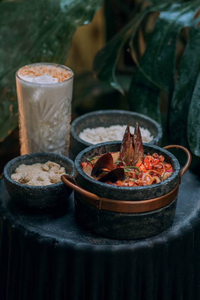 Para partilhar, o chef traz a belíssima feijoadade frutos do mar, que leva feijão branco cozido nocaldo de camarão, polvo, lula, e acompanha farofae arroz de coco. Perfeito para acompanhar a feijoada ou até ser degustado só, o Pancadinhaé um drinque de rum, leite de coco e limão siciliano. Para partilhar, o chef traz a belíssima feijoadade frutos do mar, que leva feijão branco cozido nocaldo de camarão, polvo, lula, e acompanha farofae arroz de coco. Perfeito para acompanhar a feijoada ou até ser degustado só, o Pancadinhaé um drinque de rum, leite de coco e limão siciliano.