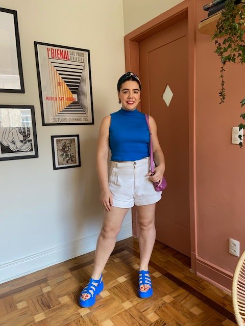 A stylist Mayra Silva vestindo shorts e uma blusa, em outra combinação.