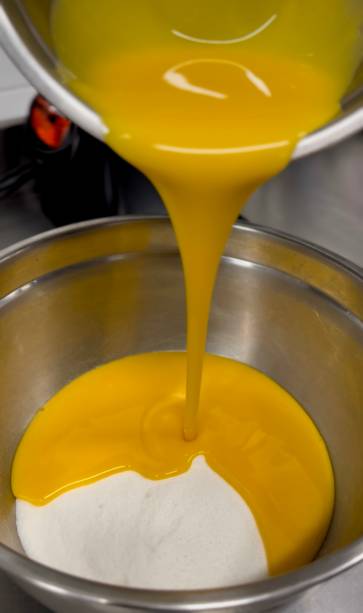 Passo 3: Derrame 1/3 sobre as gemas e o açúcar, misturando rapidamente. Junte o restante de leite quente e misture bem Passo 3: Derrame 1/3 sobre as gemas e o açúcar, misturando rapidamente. Junte o restante de leite quente e misture bem