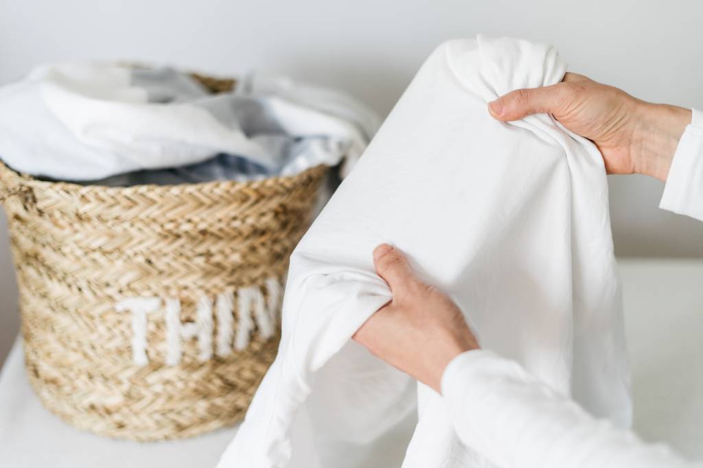 cropped shot of hands holding clean bed linen indoors cropped shot of hands holding clean bed linen indoors