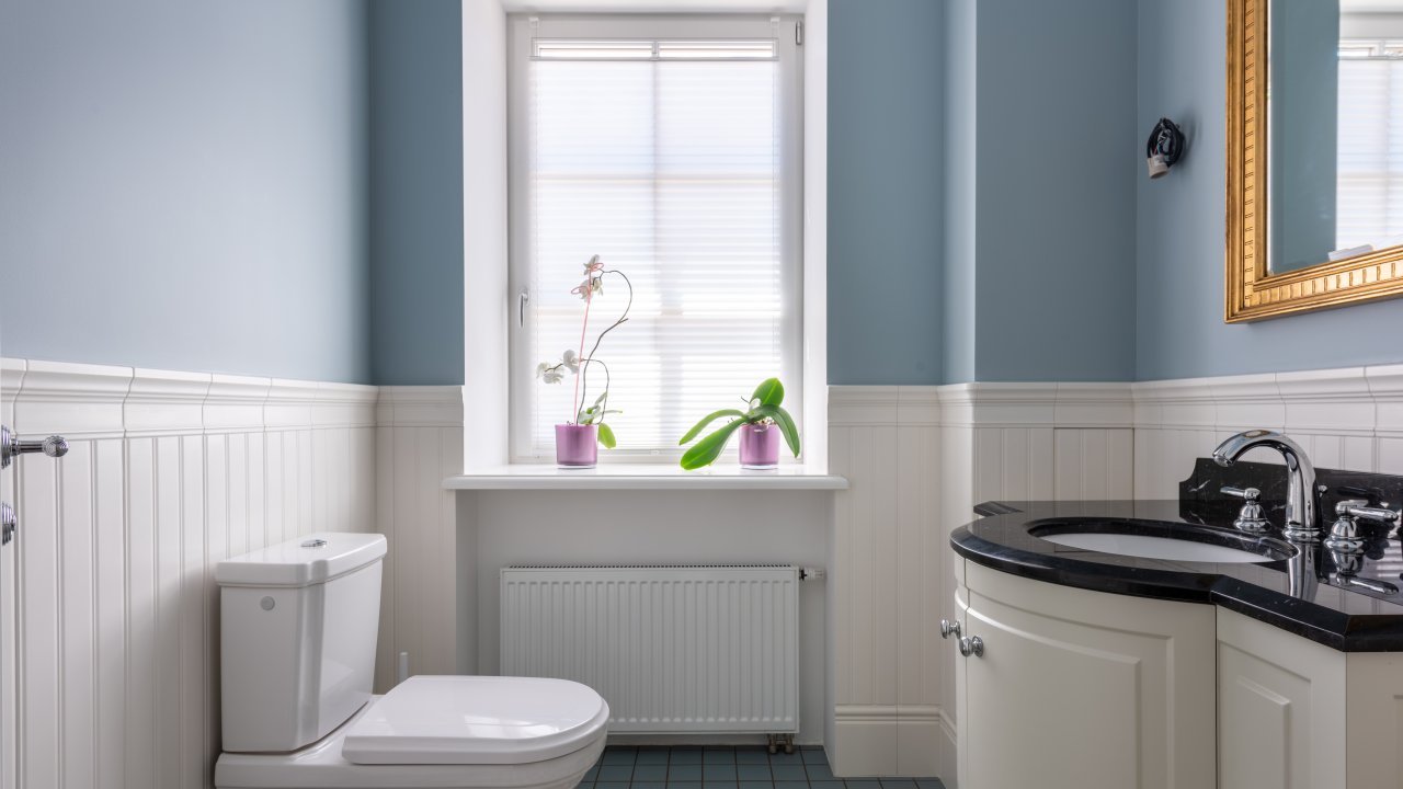Banheiro estilo retrô com tons de azul e piso hidráulico