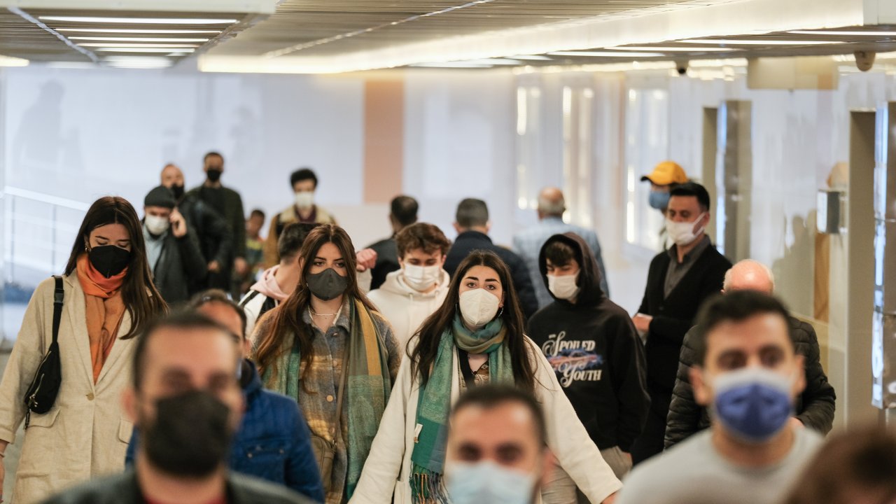Aeroporto onde pessoas estão circulando com máscaras