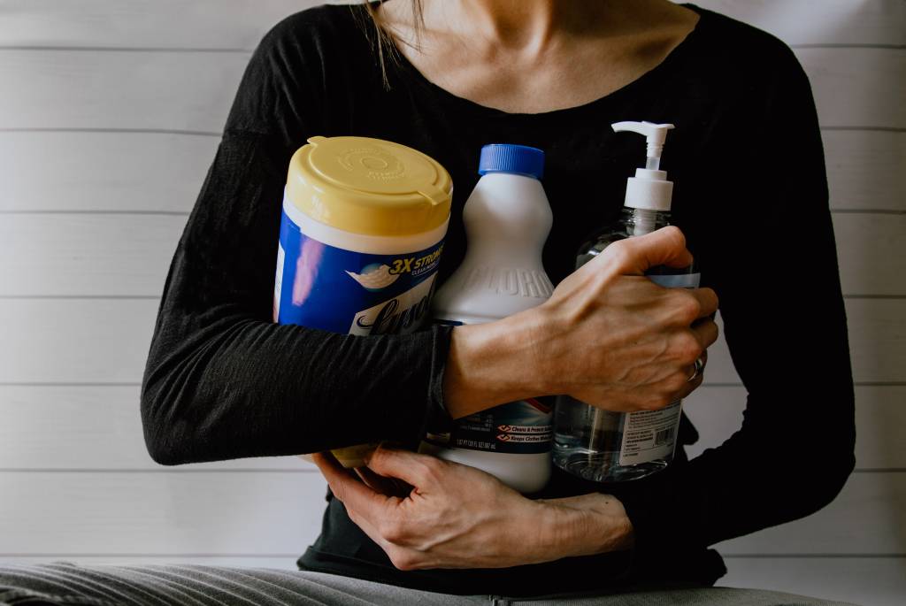 dados-alarmantes-cuidados-produtos-limpeza-intoxicação Mulher segurando produtos de limpeza