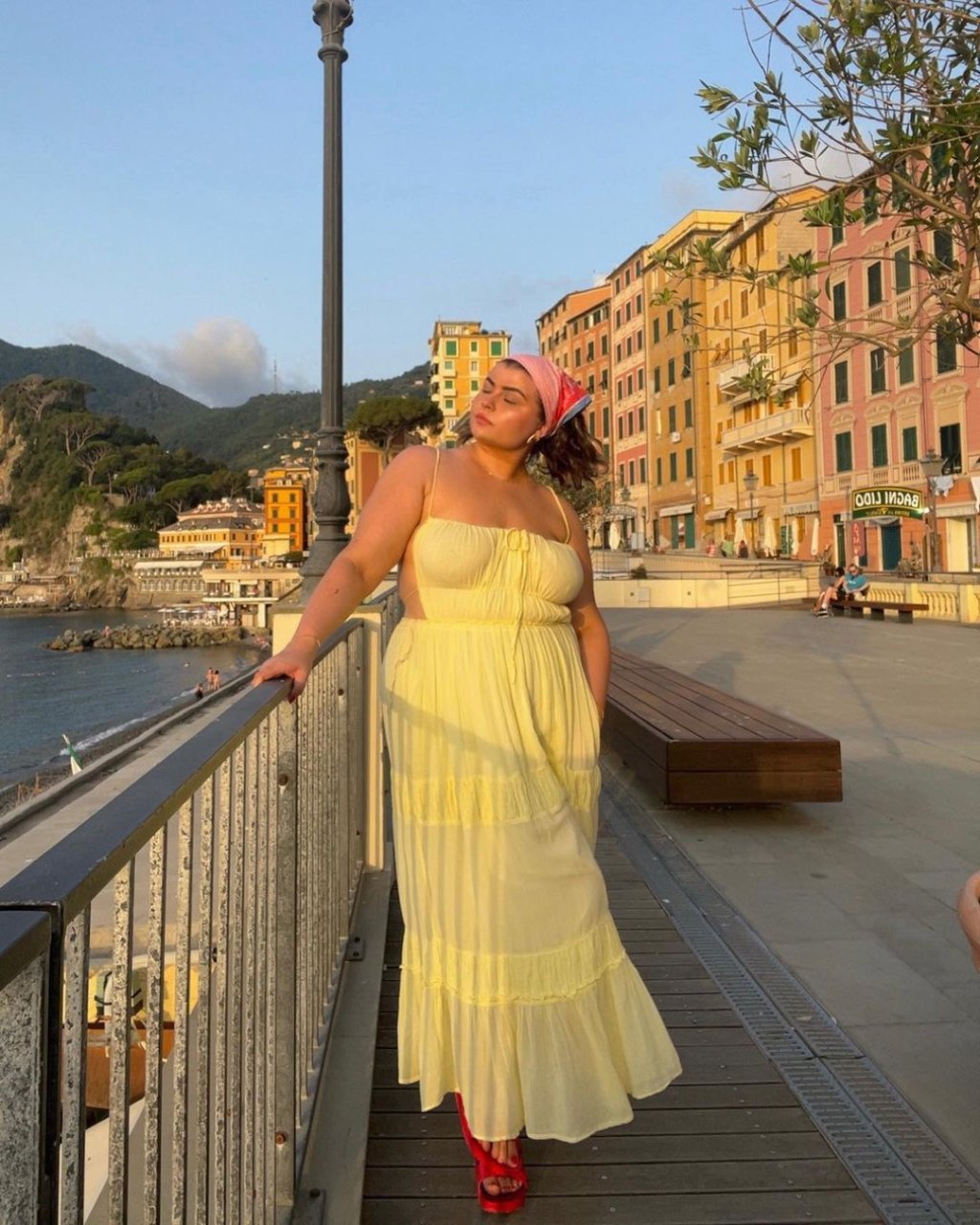 Mulher usando vestido amarelo plus size com sandália e lenço