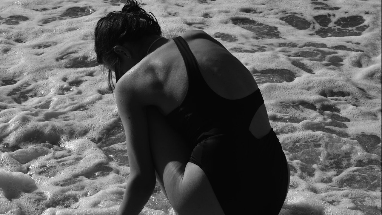 Mulher de costas sozinha no mar
