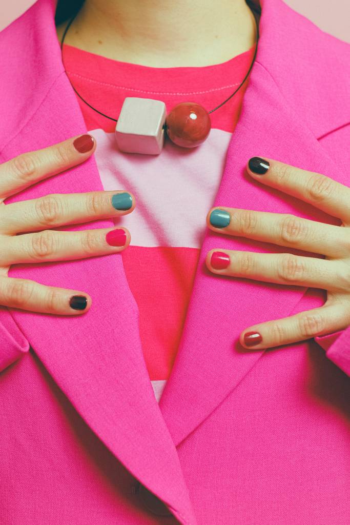 unhas-estilo-esmalte-cores-nail-art Mulher vestida com blazer rosa destacando suas unhas