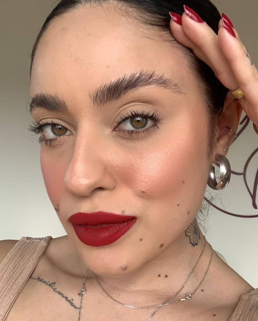 brown-lamination-técnica-profissional-sobrancelhas-tendência Mulher usando batom vermelho e com destaque para as sobrancelhas