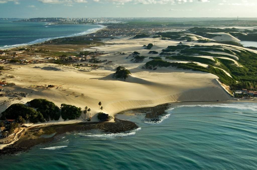 Aerial view of the isthmus of Genipabu covered with sand dunes formation and tropical flora in the district of Extremos, Rio Grande do Norte, Brazil