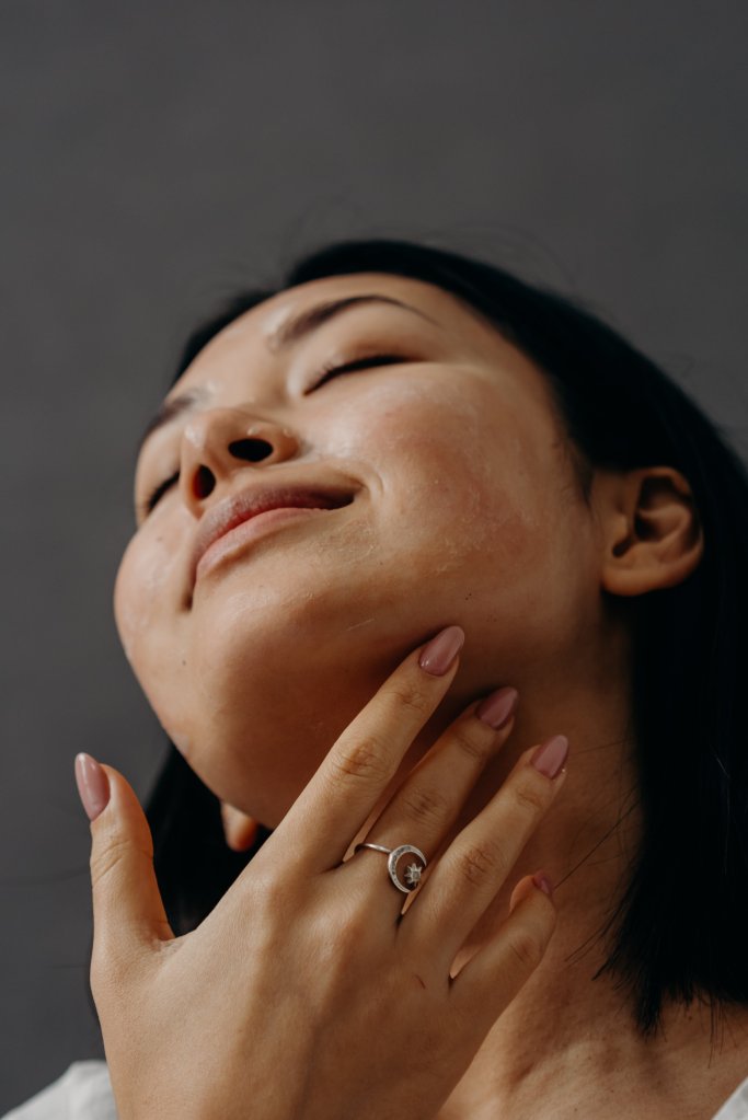Mulher aplicando ácido no rosto e pescoço