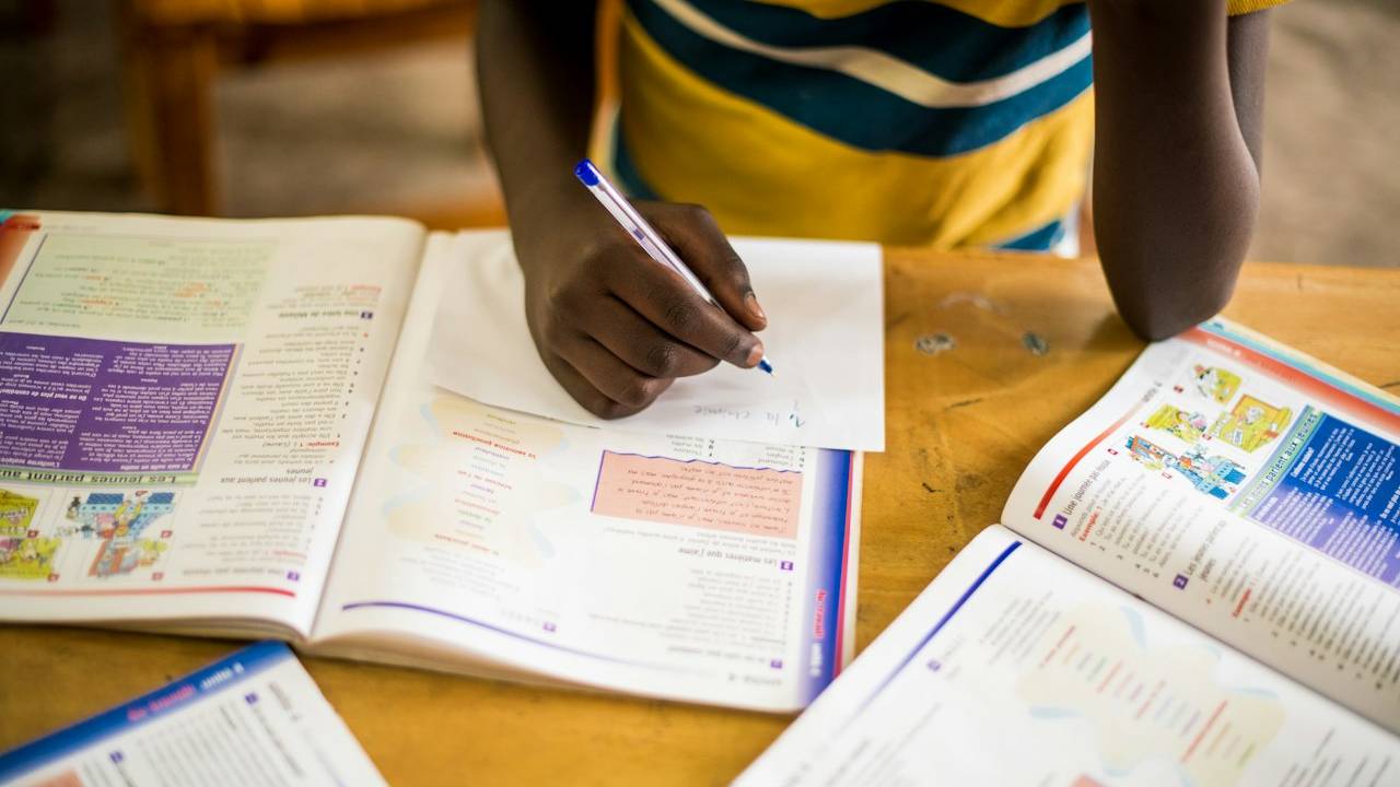 Criança estudando em meio a livros