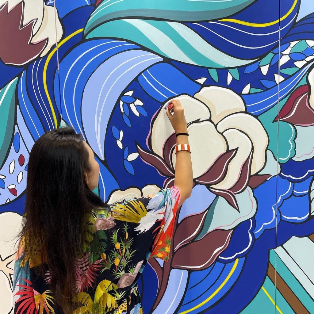 Camila Gondo realizando um mural