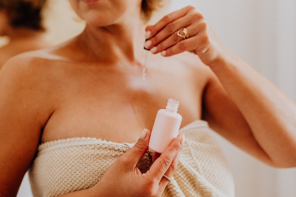 Mulher aplicando cleansing oil sobre o corpo