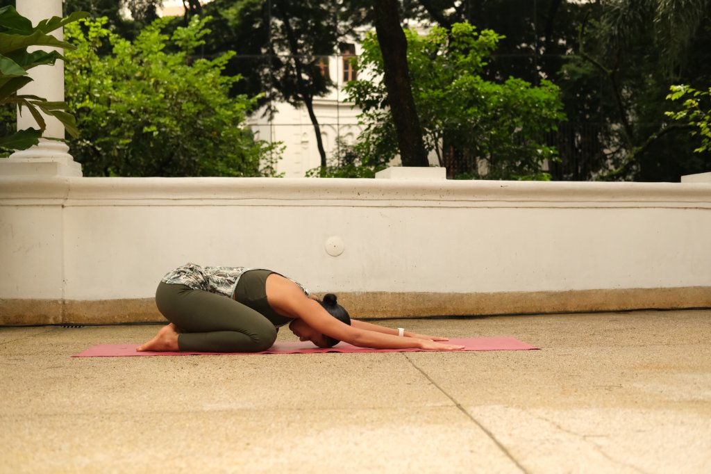 Nathalia Cuturic, professora de yoga no Vidya Studio praticando a posição da criança