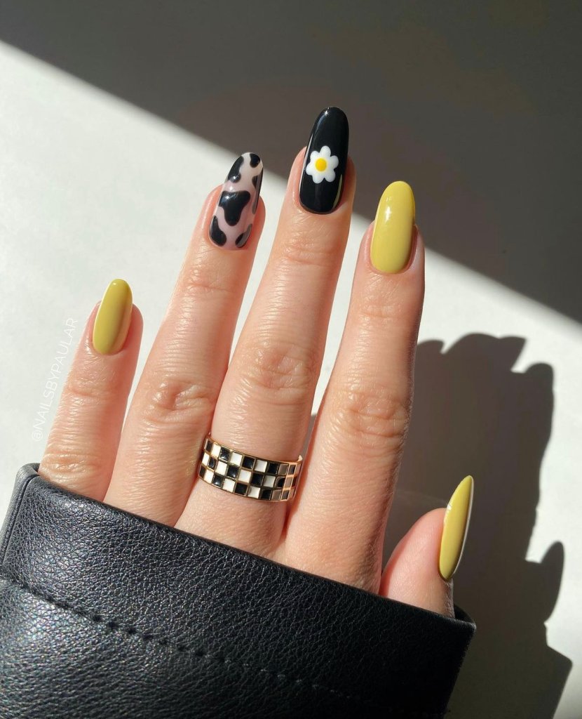 nail art amarela com desenhos preto e branco
