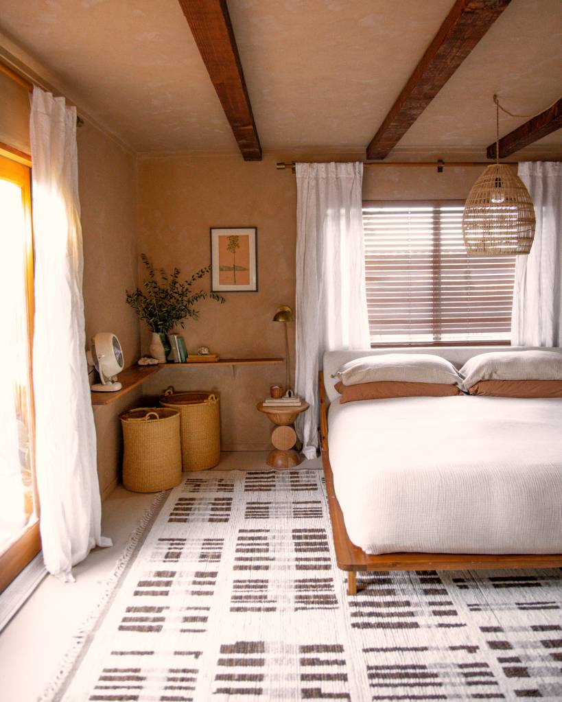 Hacienda O espaço, disponível no AirBnb tem um quarto no tom Mocha Mousse, uma cama de casal, um tapete preto e branco e iluminação natural