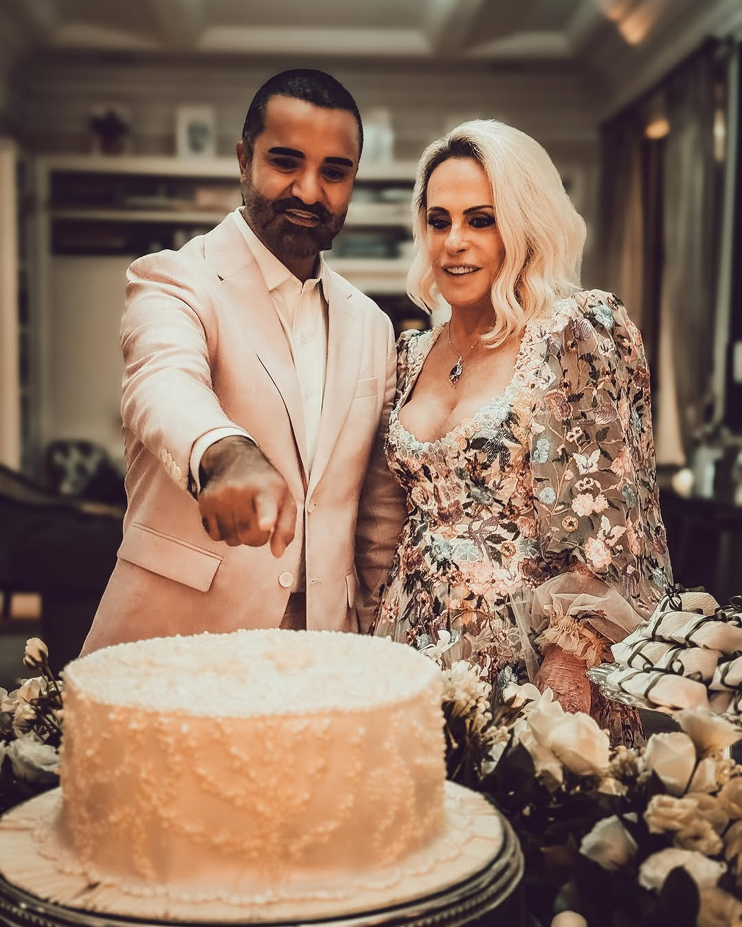 Ana Maria Braga e Fábio Arruda veem o bolo de seu casamento