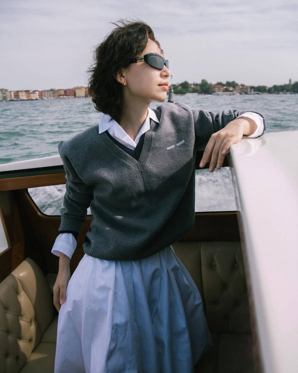 saia-plissada-camisa-polo-miumiu mulher usando camiseta polo com agasalho e saia plissada