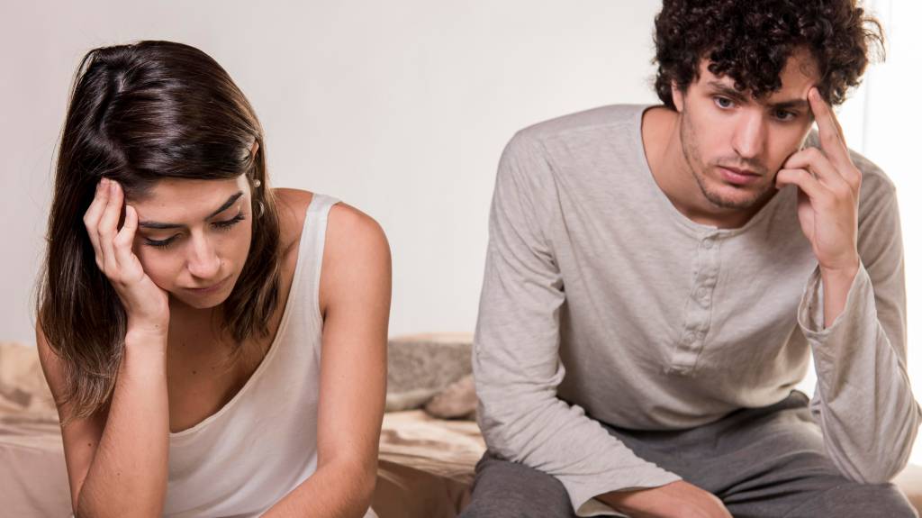 como evitar o termino_2 Imagem de homem e mulher angustiados. Eles estão sentados segurando a cabeça