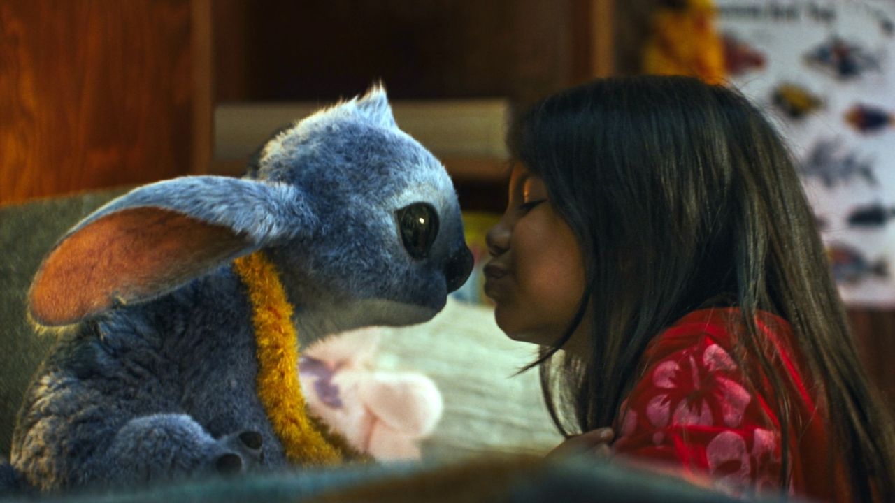 Imagem de menina beijando o nariz de bichinho azul