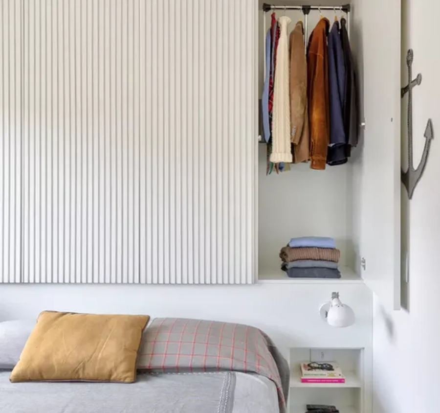 guarda-roupa-planejado-minimalista Roupeiro na parte superior da cama, com portas ripadas | Projeto assinado pelo escritório Antonio Armando de Araujo Arquitetura e Design