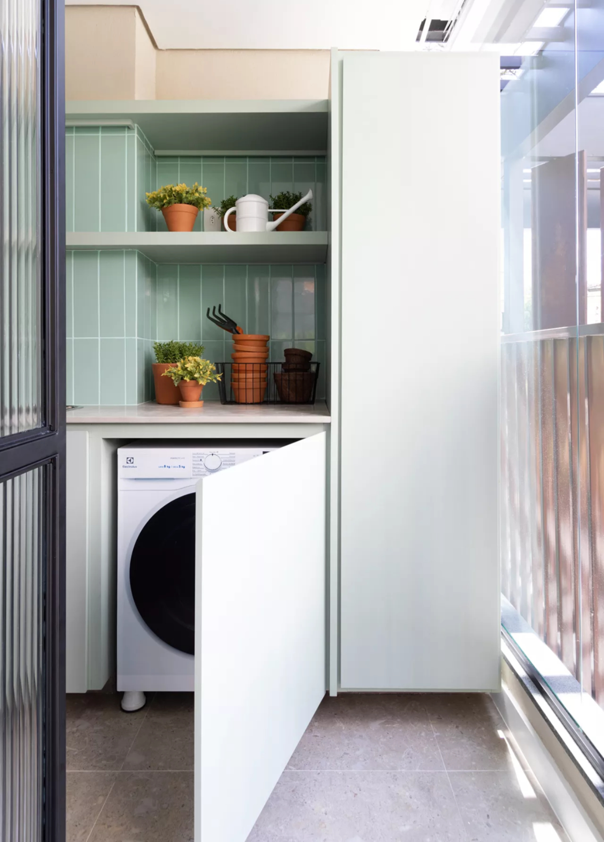 Porta esconde a máquina de lavar nesta lavanderia pequena | | Projeto assinado pelo escritório Todos Arquitetura