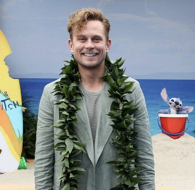 lilo-stitch-elenco_2 Imagem de homem loiro visto de frente com um colar havaiano de folhas