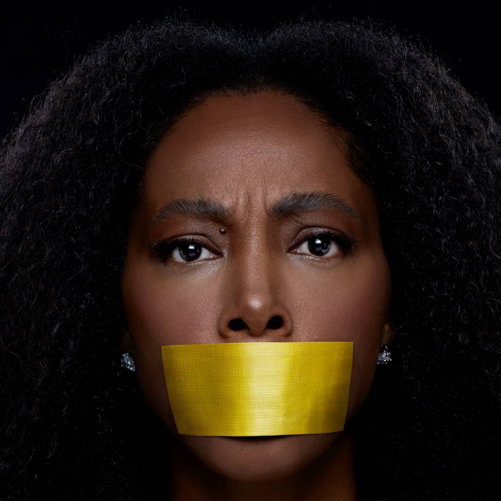 negra-li-lancamento Imagem de Negra Li vista de frente fom uma fita dourada cobrindo sua boca