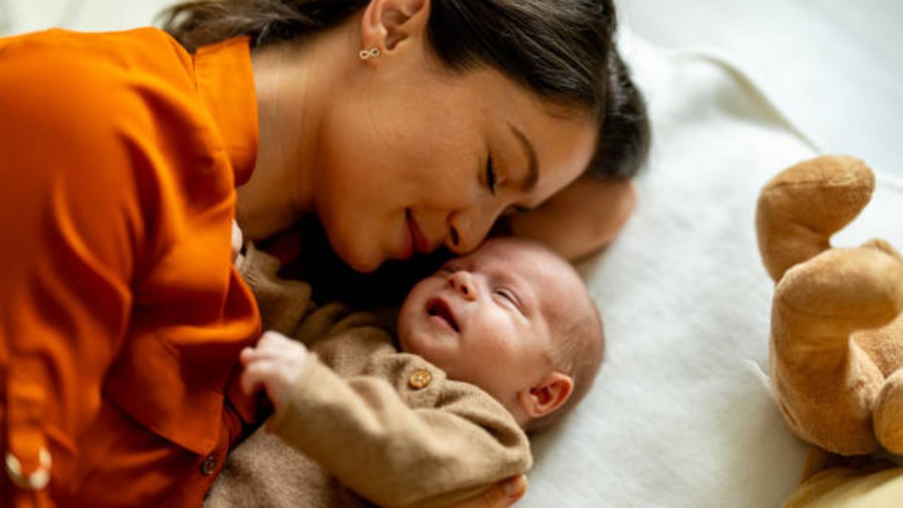 Imagem de mulher deitada ao lado de um bebê