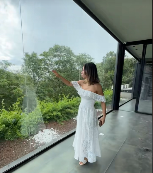 Imagem de mulher vestida de branco, vista de lado, mostrando uma paisagem