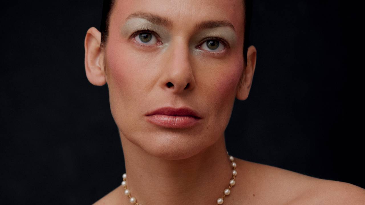 Imagem de mulher branca exibindo maquiagem delicada e feminina. O fundo é preto.