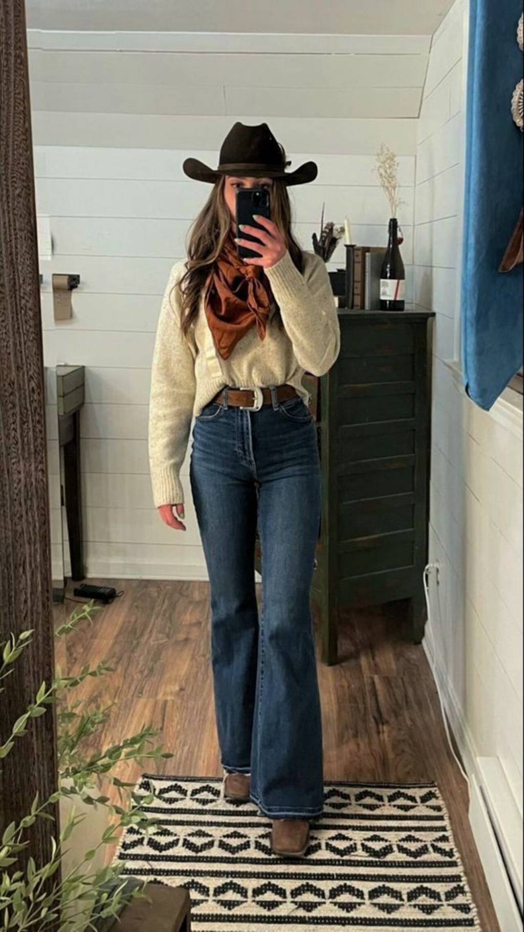 flaire-festa-junina Imagem de mulher morena usando look com calça flaire jeans, blusa de frio branca e lenço marrom no pescoço.