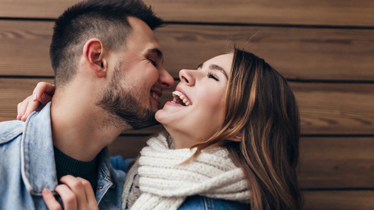 Casal abraçado com mulher rindo de seu senso de humor