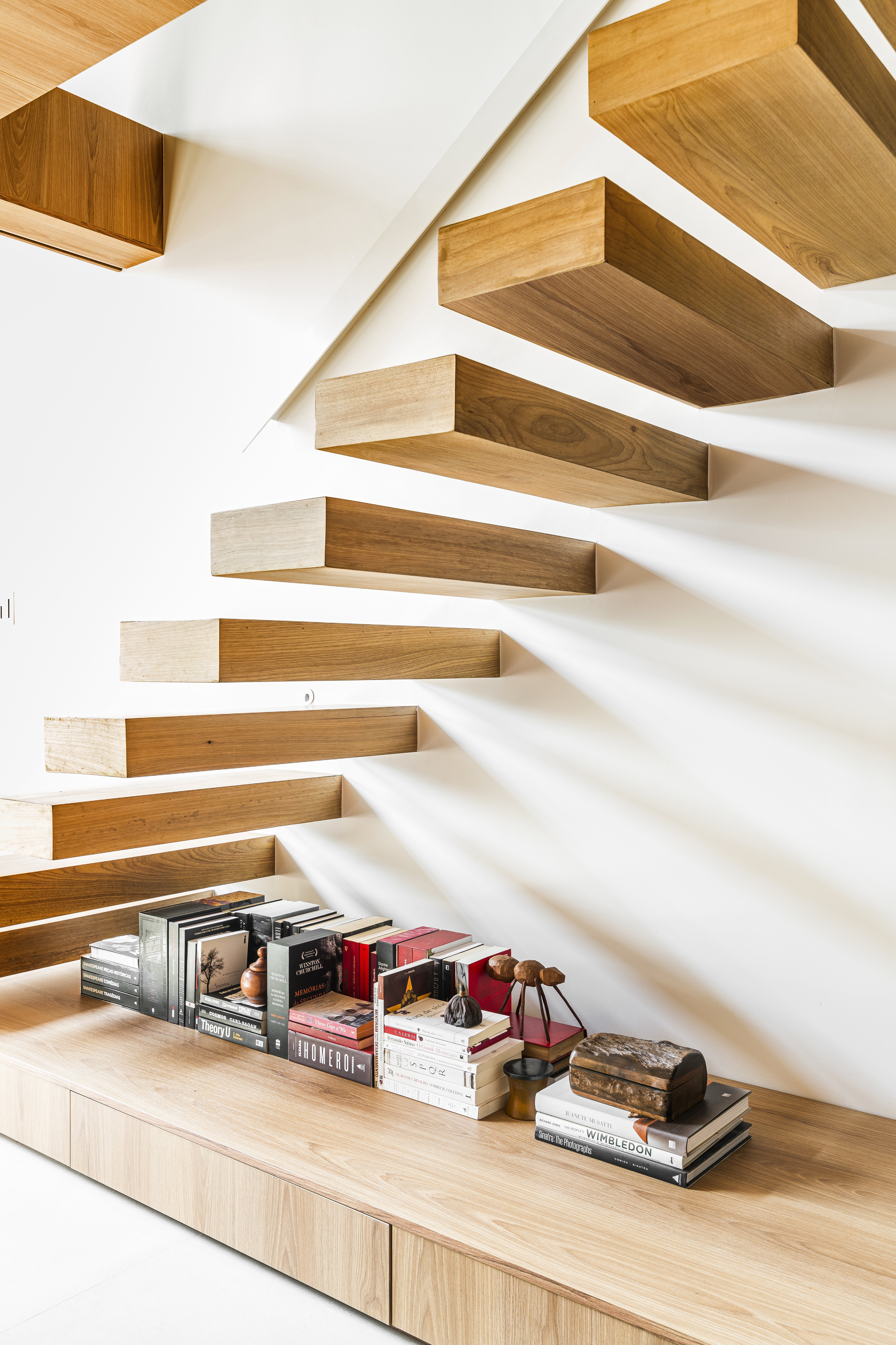Livros empilhados no chão podem complementar ambientes com elegância.