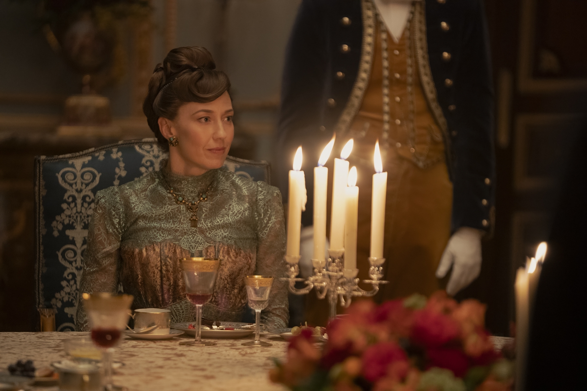 Imagem de mulher em cena de jantar de época na série The Gilded Age