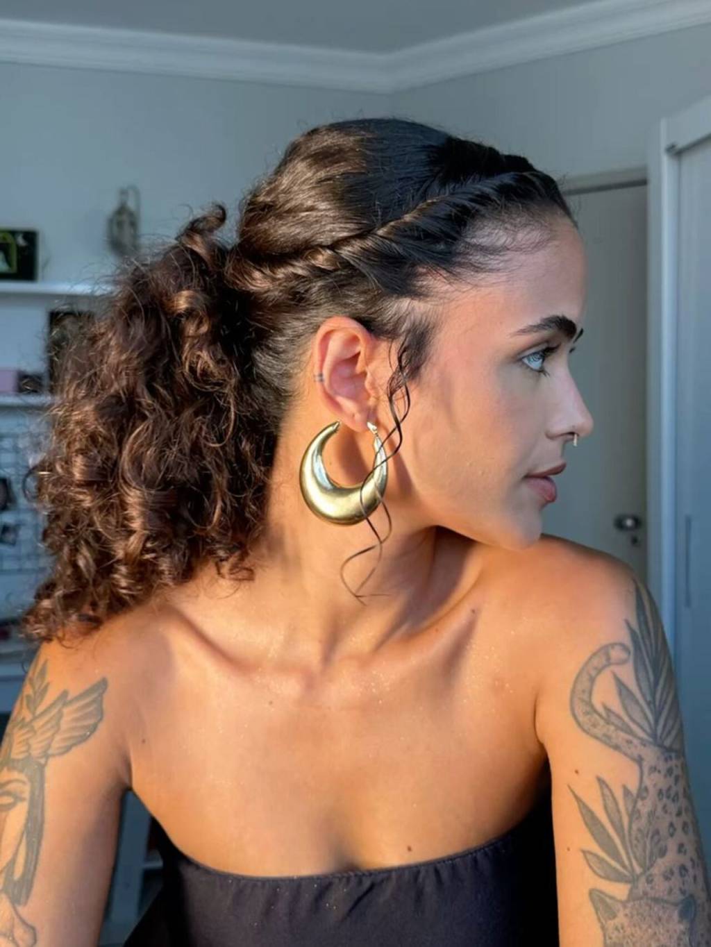 penteados-juninos-cacheados (9) Imagem de mulher morena de perfil com penteado preso com efeito torcido nos fios.