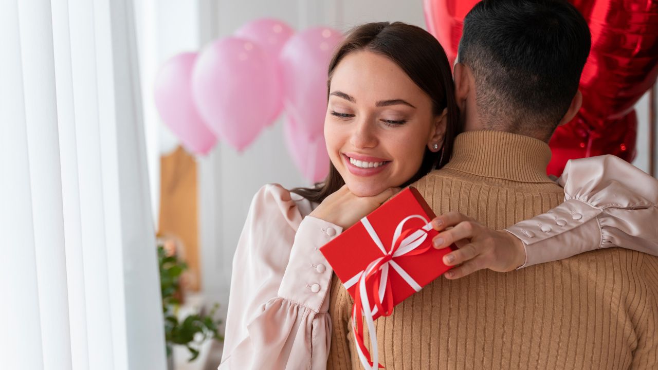 Casal se abraça enquanto entregam presentes comprados para o dia dos namorados