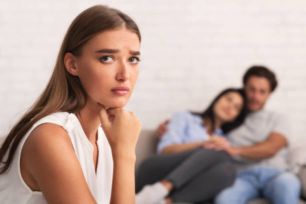 Imagem de uma mulher triste e um casal abraçado ao fundo