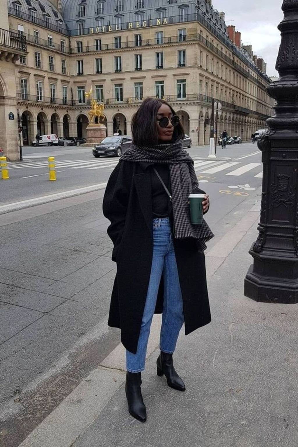 sobretudo-cachecol (1) Imagem de mulher negra com sobretudo preto, calça jeans, cachecol quadriculado e botas.