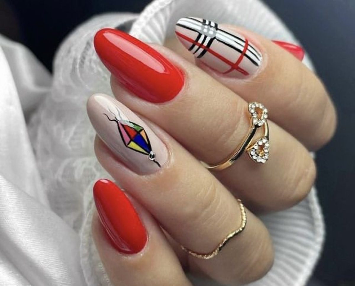 Imagem de mão exibindo unhas vermelhas com xadrez e balão de São João.