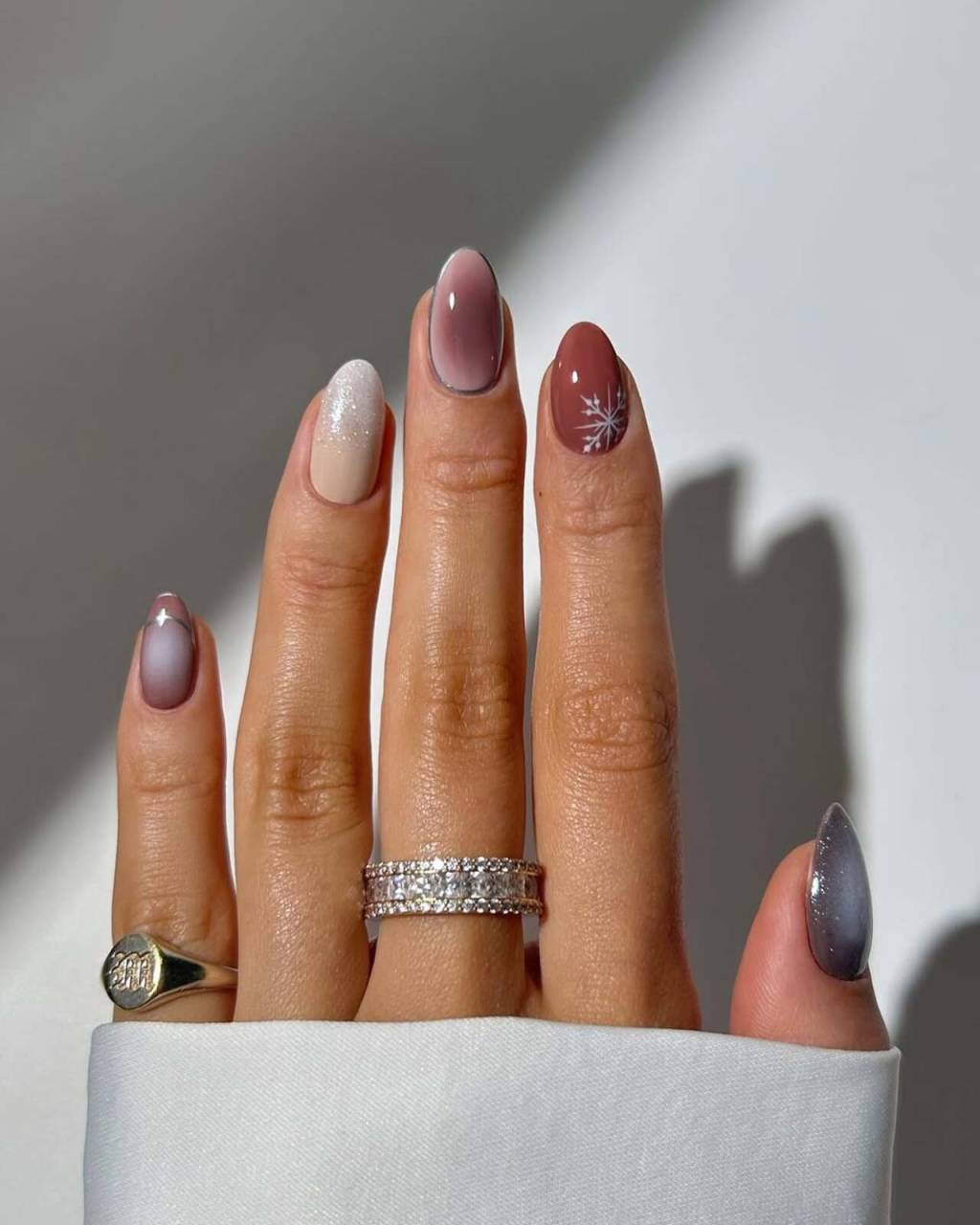 unhas-tematicas-inverno (9) Imagem de mão branca exibindo nail art marrom e azul temática para o inverno.