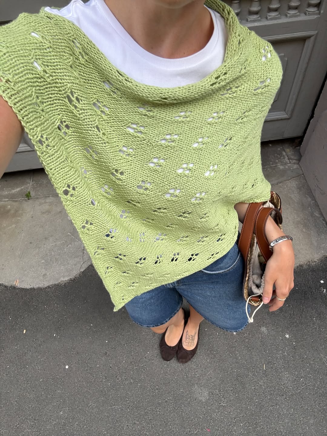 Look com poncho de crochê verde e short jeans