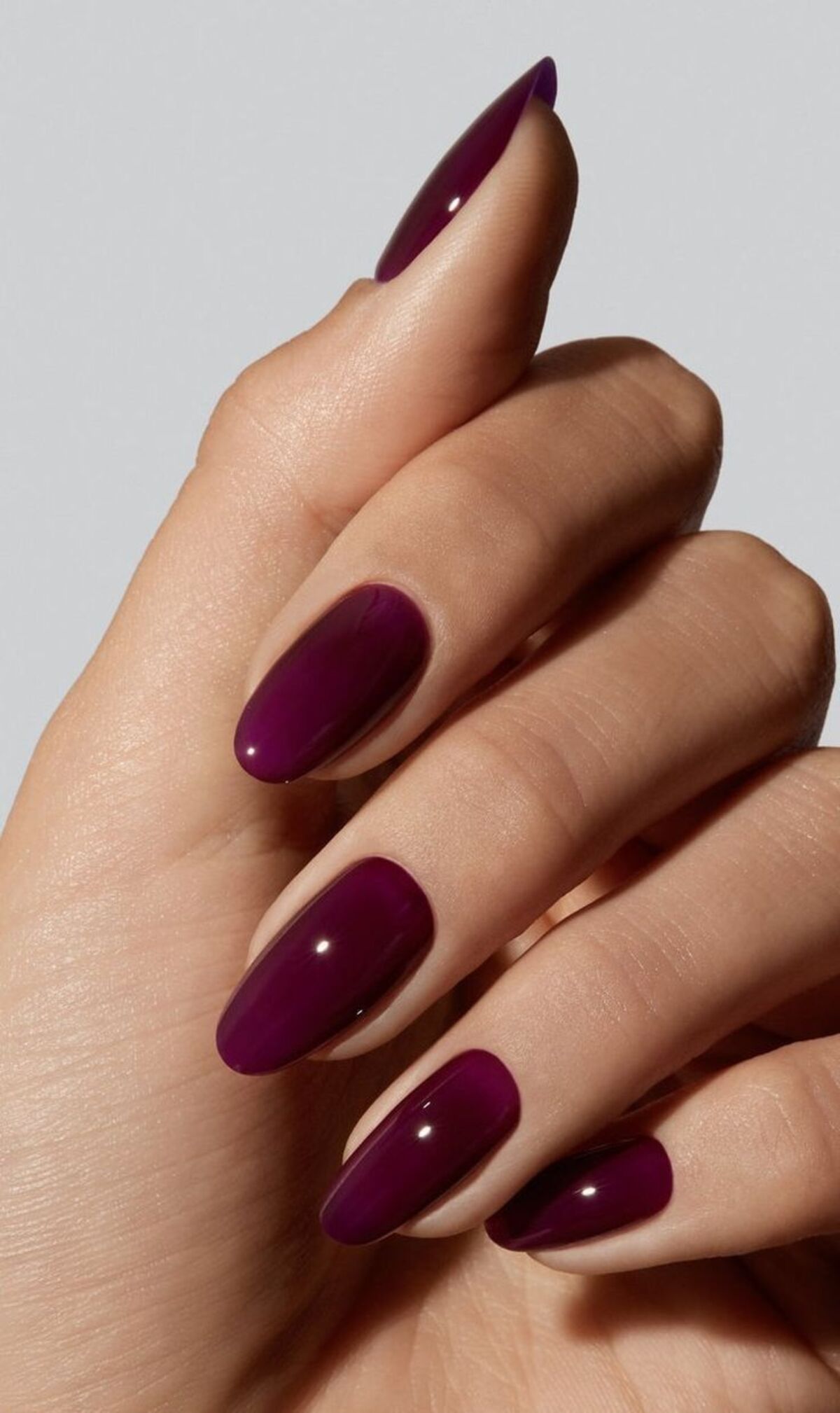 Imagem mostra unhas com esmaltação roxa.