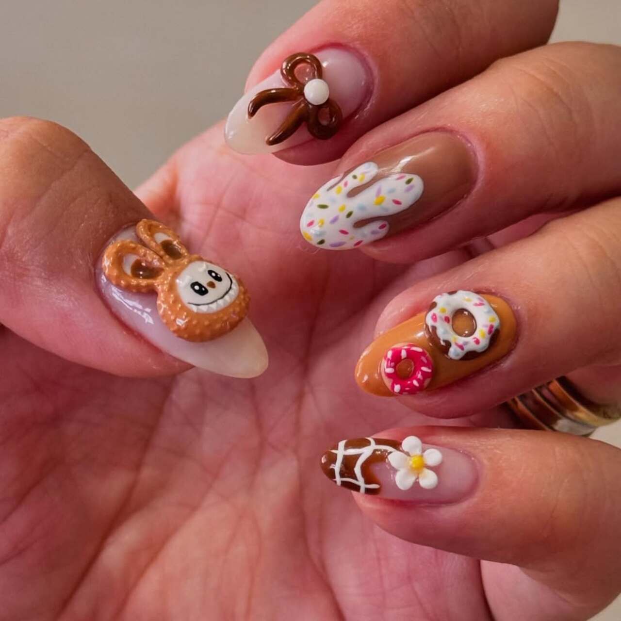 Imagem mostra nail art marrom de labubu.