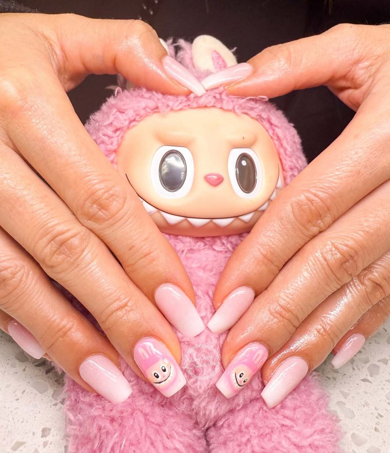 Imagem mostra nail art rosa de labubu.