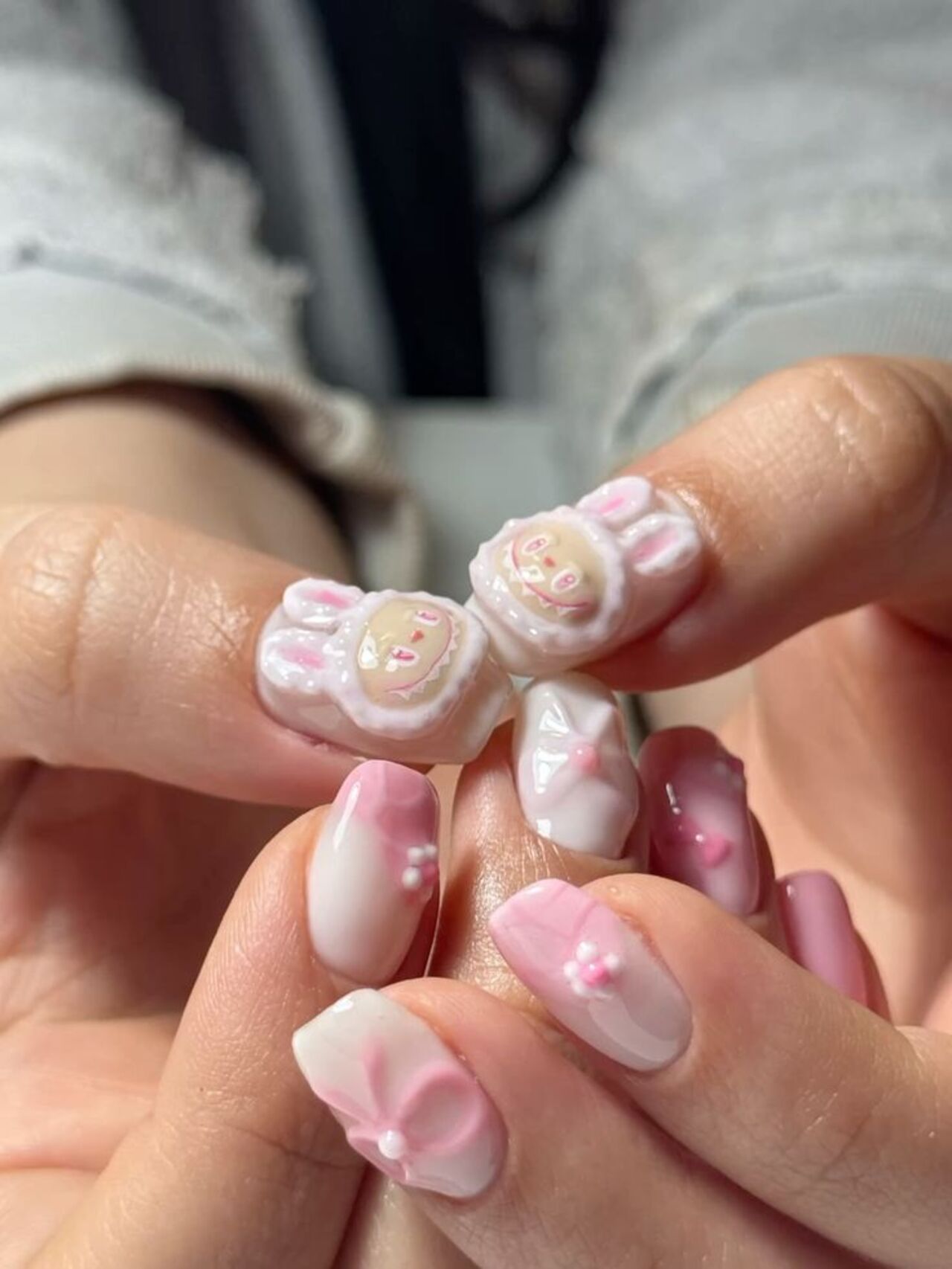 Imagem mostra nail art de labubu em tons de rosa.