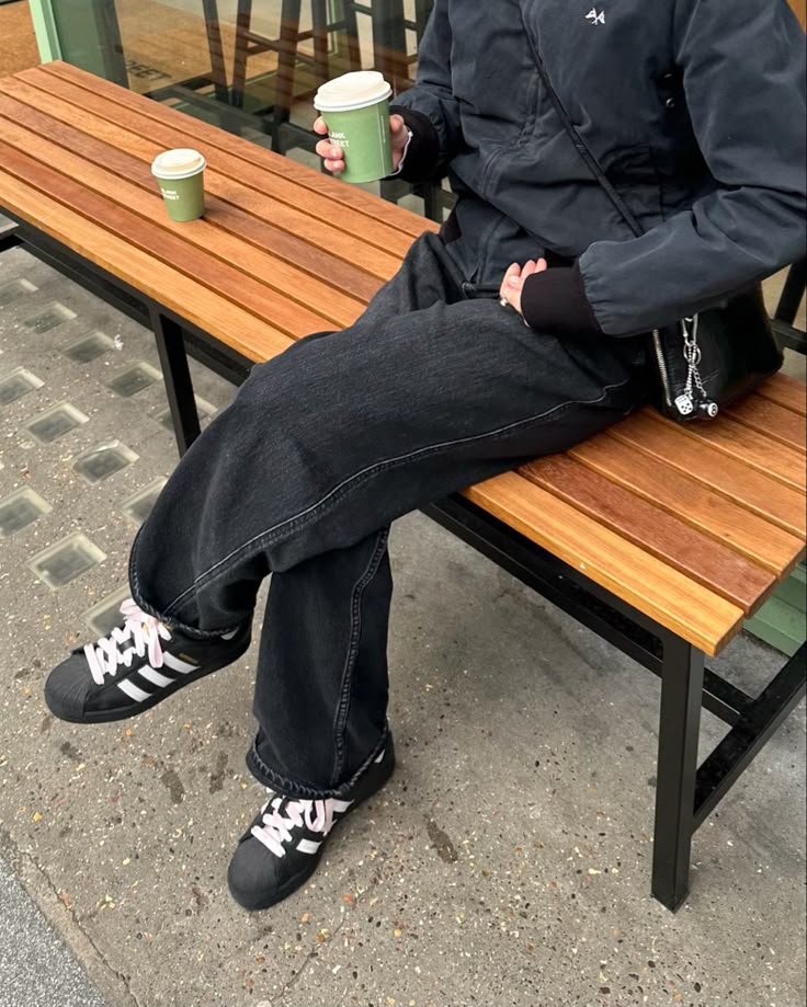 Look all black com jeans escuro e tênis Adidas Superstar, que está voltando à moda