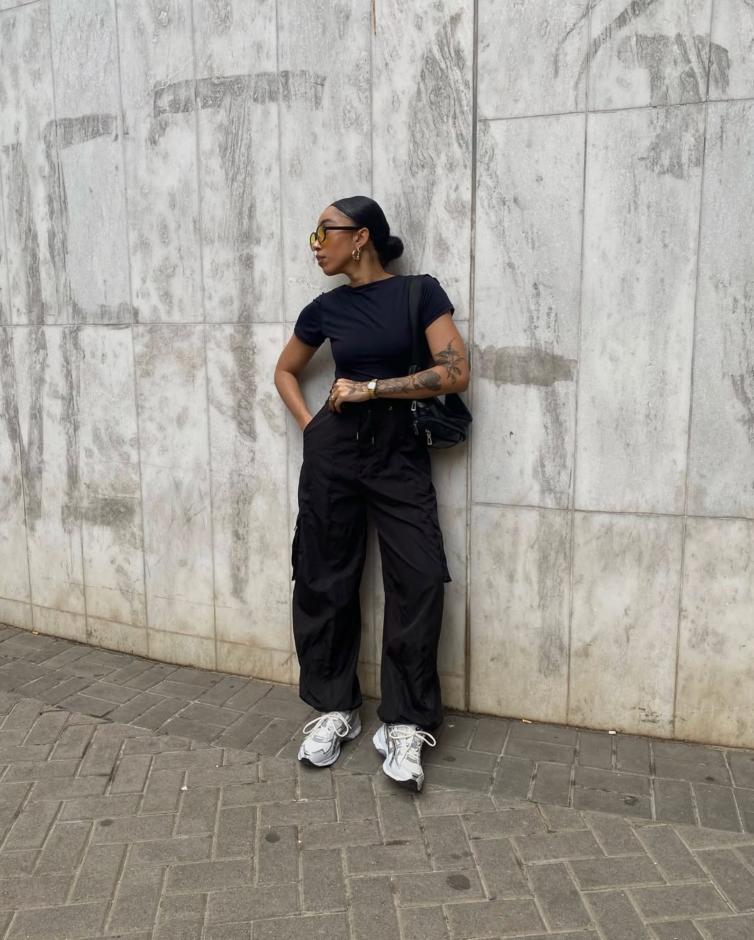 Look com tênis Asics branco e calça jeans preta estilo cargo