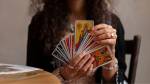 Imagem de mulher segurando as cartas do tarô semanal