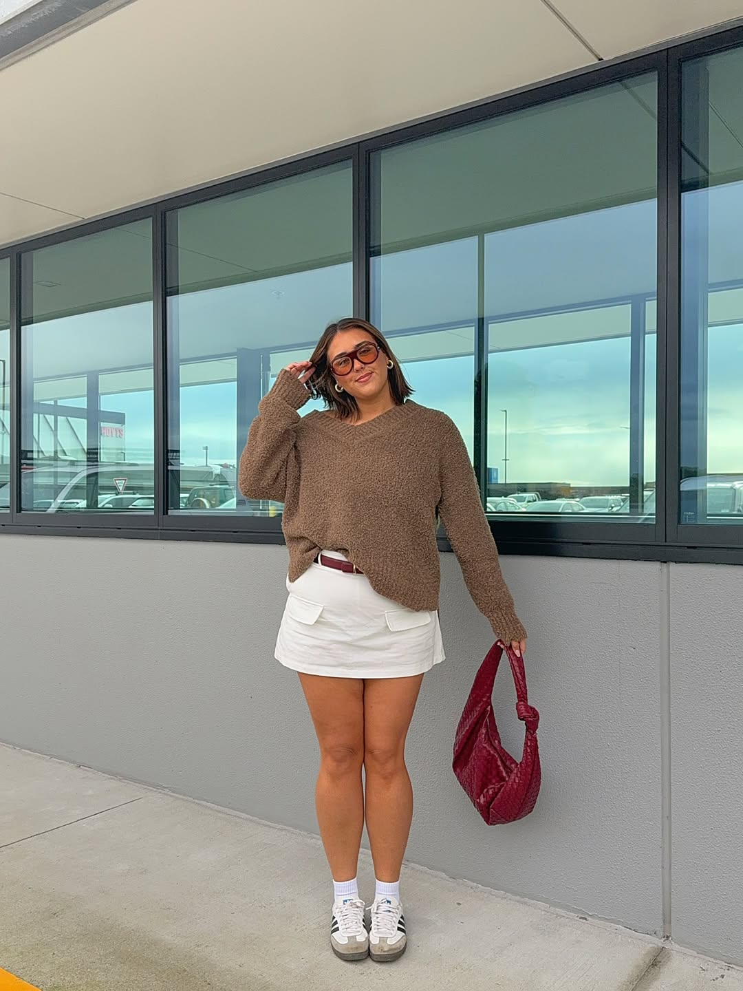 Look casual com suéter marrom e minissaia branca
